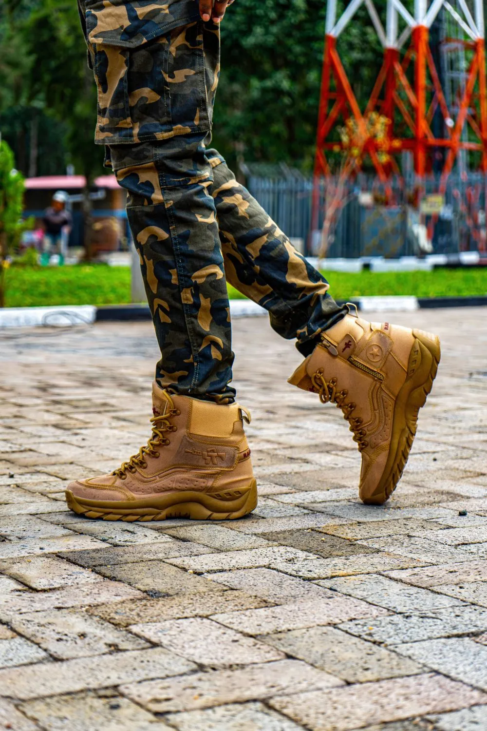 Par de botas de cuero color miel caminando sobre una vereda de adoquines
